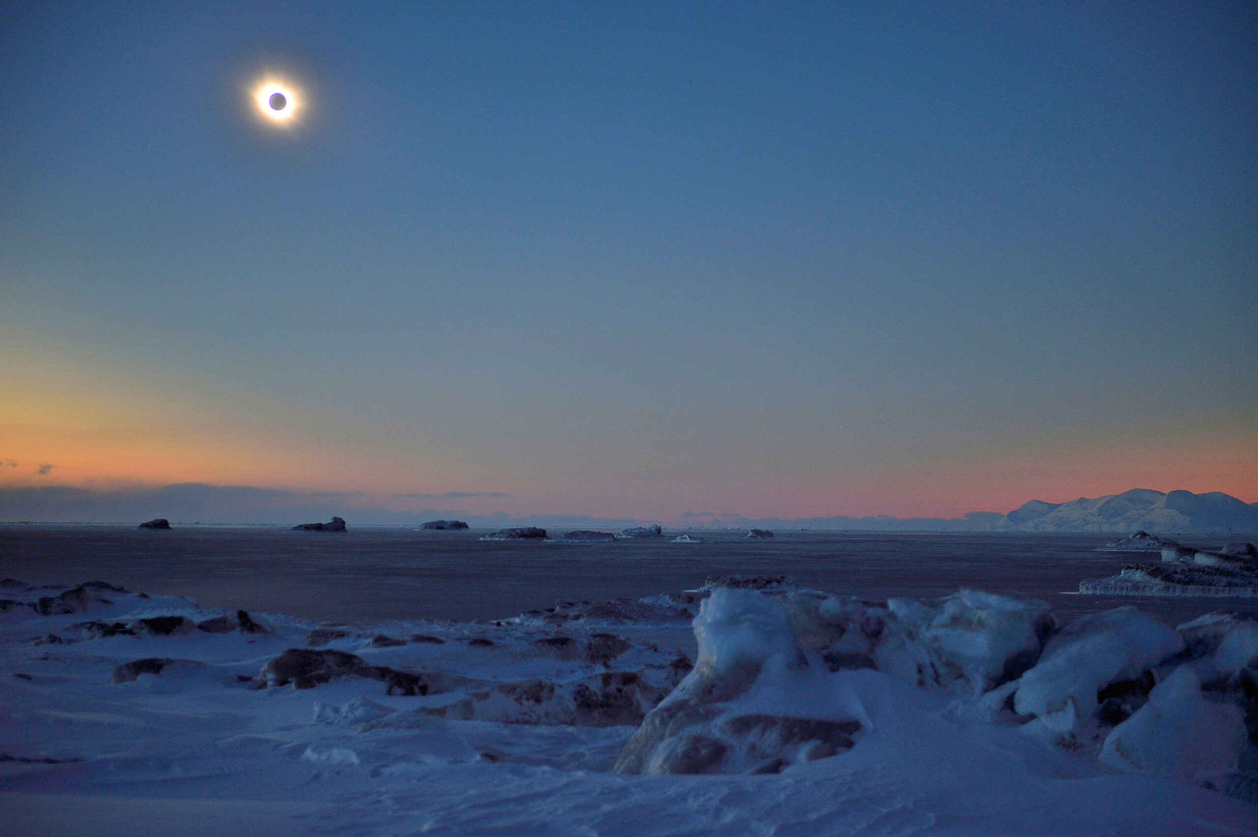 Sun and moon in arctic during eclipse